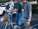 The testing team down in the parking lot with a rig for testing and the measurement gear. Kerry Banke, N6IZW, adjusts the receiving antenna system while Dave Hartzell, AF6KD, looks on.